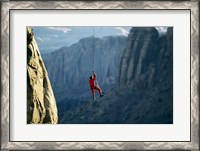Framed Rear view of a man rappelling down a rock