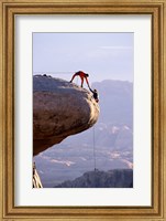 Framed Side profile of a young man pulling a young woman onto a rock