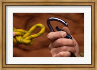 Framed Close-up of human hands holding a carabiner and rope