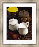 Framed Close-up of a mug of milk with a measuring spoon and jars on coffee beans