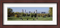Framed Four people playing golf with buildings in the background, Denver, Colorado, USA