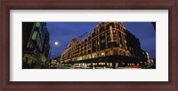 Framed Low angle view of buildings lit up at night, Harrods, London, England