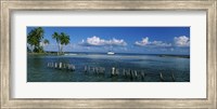 Framed Wooden posts in the sea with a boat in background, Laughing Bird Caye, Victoria Channel, Belize