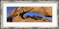 Framed Mountains viewed through a natural arch with a mother holding her baby, Spitzkoppe, Namib Desert, Namibia