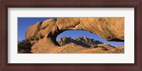 Framed Mountains viewed through a natural arch with a mother holding her baby, Spitzkoppe, Namib Desert, Namibia