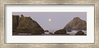 Framed Sea stacks and setting moon at dawn, Bandon Beach, Oregon, USA