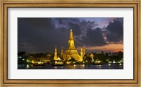 Framed Buddhist temple lit up at dawn, Wat Arun, Chao Phraya River, Bangkok, Thailand