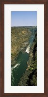 Framed Kayakers paddle down the Zambezi gorge away from the Victoria Falls, Zambia