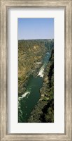Framed Kayakers paddle down the Zambezi gorge away from the Victoria Falls, Zambia
