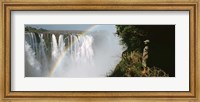 Framed Woman looking at a rainbow over the Victoria Falls, Zimbabwe