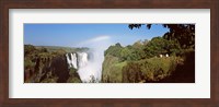 Framed Tourists at a viewing point looking at the rainbow formed over Victoria Falls, Zimbabwe