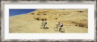 Framed Side profile of two men mountain bilking on rocks, Slickrock Trail, Moab, Utah, USA