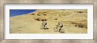 Framed Side profile of two men mountain bilking on rocks, Slickrock Trail, Moab, Utah, USA