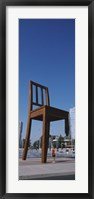 Framed Woman standing under a sculpture of large broken chair, Geneva, Switzerland