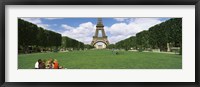 Framed Tourists sitting in a park with a tower in the background, Eiffel Tower, Paris, Ile-de-France, France