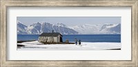 Framed Two hikers standing on the beach near a hunting cabin, Bellsund, Spitsbergen, Svalbard Islands, Norway