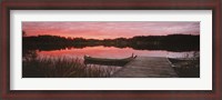 Framed Canoe tied to dock on a small lake at sunset, Sweden