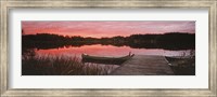 Framed Canoe tied to dock on a small lake at sunset, Sweden