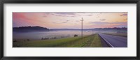 Framed Country road and telephone lines splitting farmlands at dawn, Finland