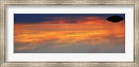 Framed Reflection of clouds with circular ripples spreading outward across glassy lake waters at sunset