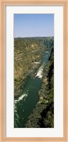 Framed Kayakers paddle down the Zambezi gorge away from the Victoria Falls, Zambia