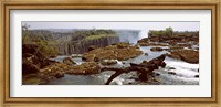 Framed Log on the rocks at the top of the Victoria Falls with Victoria Falls Bridge in the background, Zimbabwe