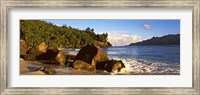Framed Waves splashing onto rocks on North Island with Silhouette Island in the background, Seychelles