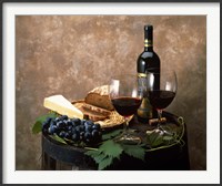 Framed Still life of wine bottle, wine glasses, cheese and purple grapes on top of barrel