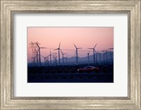 Framed Car moving on a road with wind turbines in background at dusk, Palm Springs, Riverside County, California, USA
