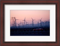 Framed Car moving on a road with wind turbines in background at dusk, Palm Springs, Riverside County, California, USA