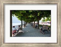 Framed People sitting on benches among trees at lakeshore, Lake Como, Cernobbio, Lombardy, Italy