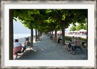 Framed People sitting on benches among trees at lakeshore, Lake Como, Cernobbio, Lombardy, Italy