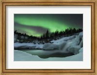 Framed wintery waterfall and aurora borealis over Tennevik River, Norway