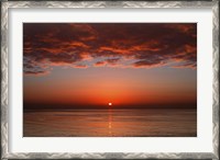 Framed layer of clouds is lit by the rising sun over Rio de la Plata, Buenos Aires, Argentina