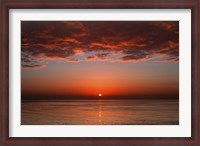 Framed layer of clouds is lit by the rising sun over Rio de la Plata, Buenos Aires, Argentina