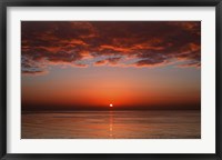 Framed layer of clouds is lit by the rising sun over Rio de la Plata, Buenos Aires, Argentina