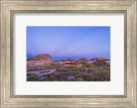 Framed Gibbous moon and crepuscular rays over Dinosaur Provincial Park, Canada