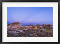 Framed Gibbous moon and crepuscular rays over Dinosaur Provincial Park, Canada