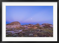Framed Gibbous moon and crepuscular rays over Dinosaur Provincial Park, Canada
