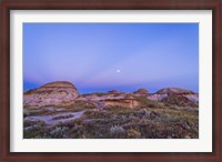 Framed Gibbous moon and crepuscular rays over Dinosaur Provincial Park, Canada