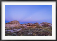 Framed Gibbous moon and crepuscular rays over Dinosaur Provincial Park, Canada