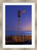Framed Venus and Jupiter are visible behind an old farm water pump windmill, Alberta, Canada