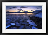 Framed Ice flakes drifting against the sunset in Tjeldsundet strait, Troms County, Norway