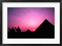 Framed Colorful Sunset Silhouetting Men and Camels at the Great Pyramids of Giza, Egypt