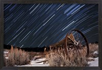 Framed Abandoned farm equipment against a backdrop of star trails