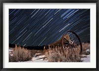 Framed Abandoned farm equipment against a backdrop of star trails