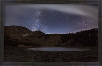 Framed Star trails and the blurred band of the Milky Way above a lake in the Eastern Sierra Nevada