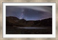 Framed Star trails and the blurred band of the Milky Way above a lake in the Eastern Sierra Nevada