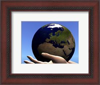 Framed planet Earth is held in caring human hands