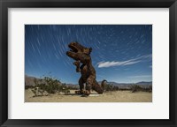 Framed Tyrannosaurus rex sculpture against a backdrop of star trails, California